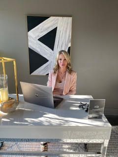 A woman is sitting at a desk with a laptop computer.