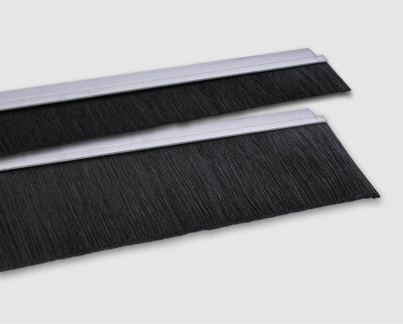A pair of black door brushes with a silver trim on a white surface.