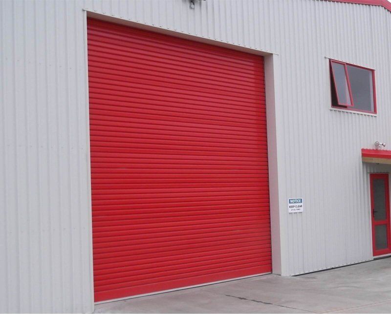 A white building with a red garage door