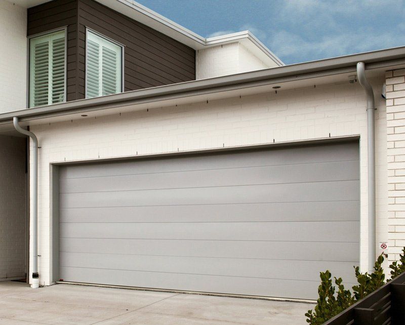 A large white house with a gray garage door