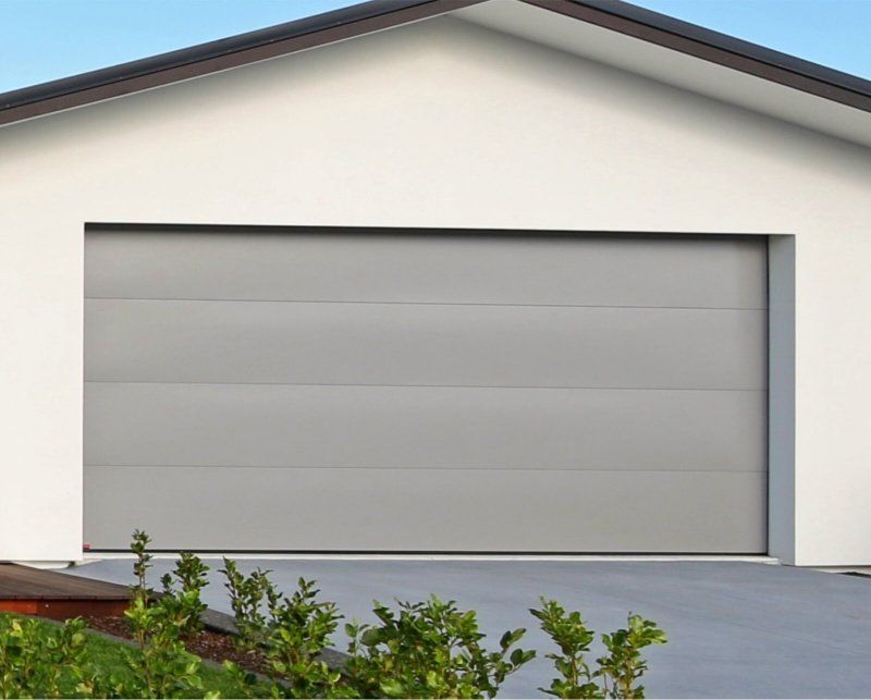 A white house with a gray garage door