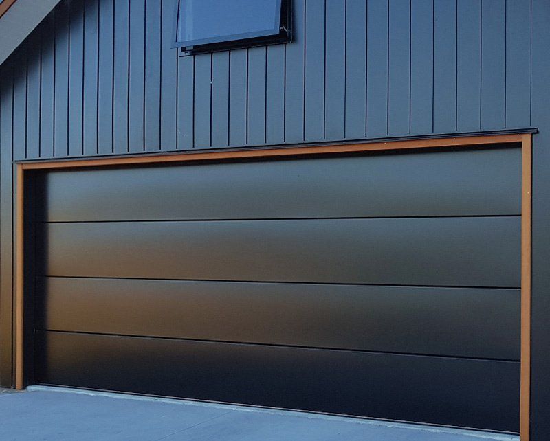 A black garage door with a wooden frame