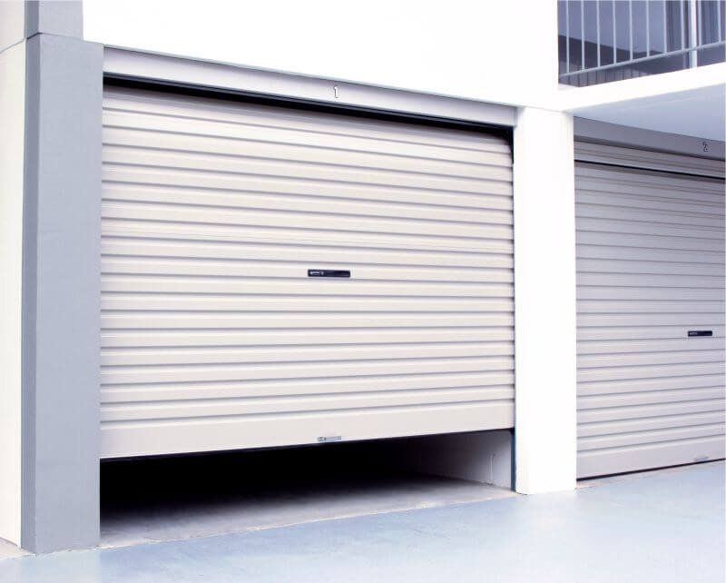 A white garage door is open in a building