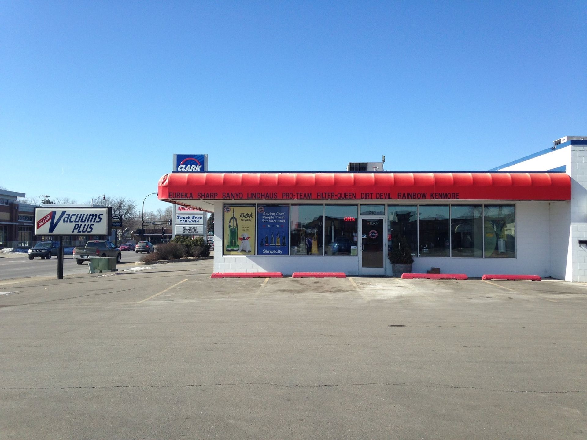 Storefront with a red awning under a clear blue sky. The store has large windows and a sign that's partially visible.