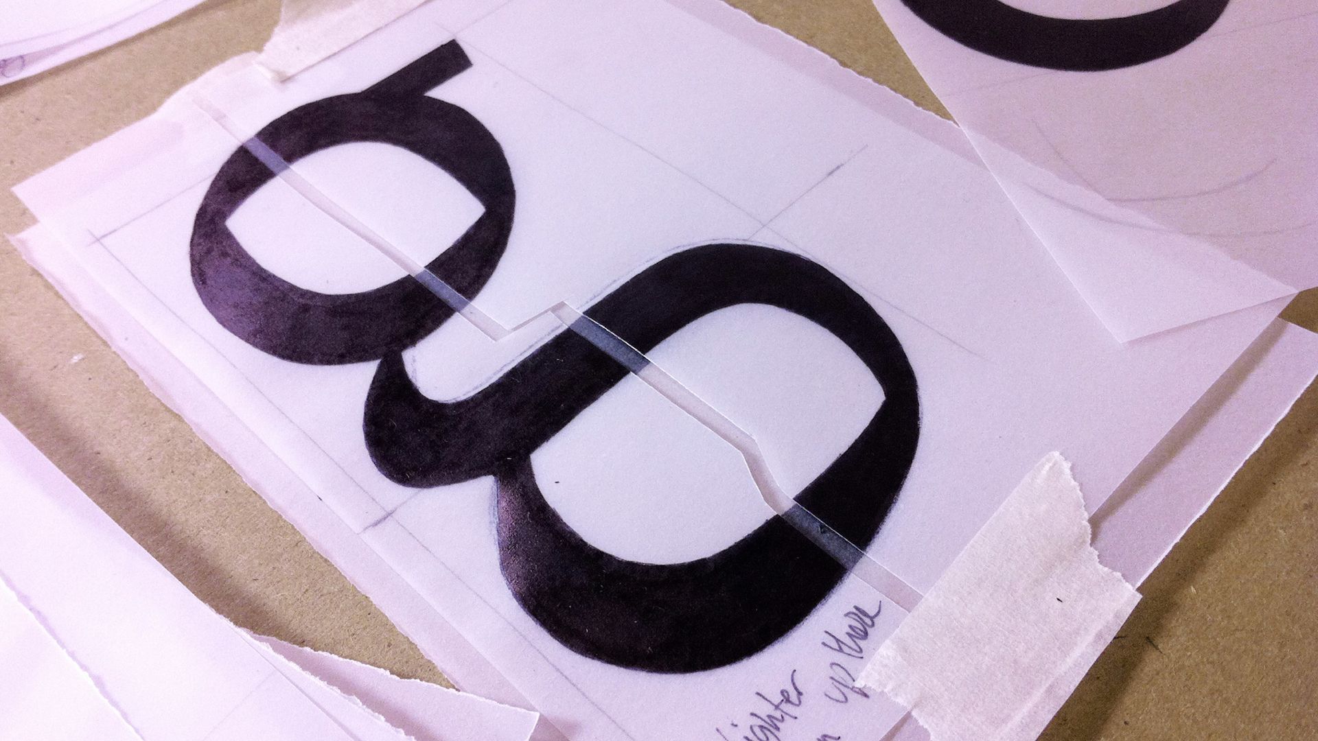 Printed black chain-link symbol on white paper, lying on a desk with another sheet beneath it.