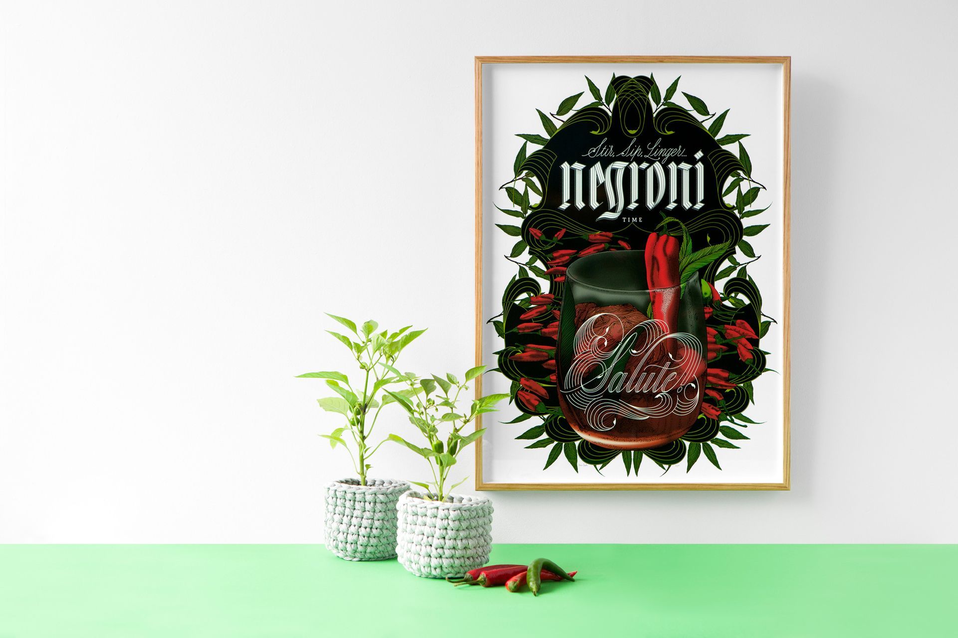 Framed botanical poster on a mint table beside two potted plants