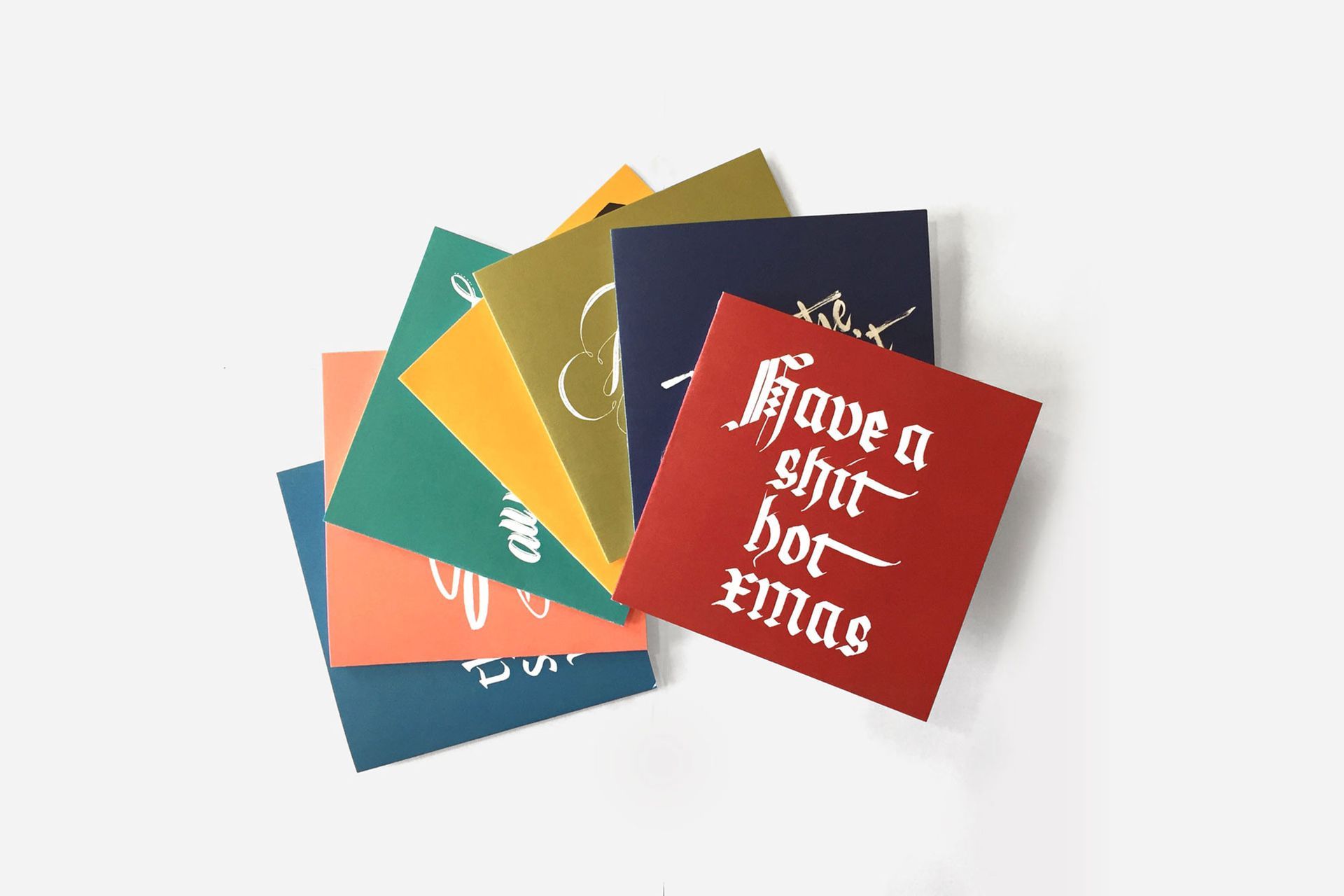 A fan of colorful square cards against a white background, featuring the red top card with the text