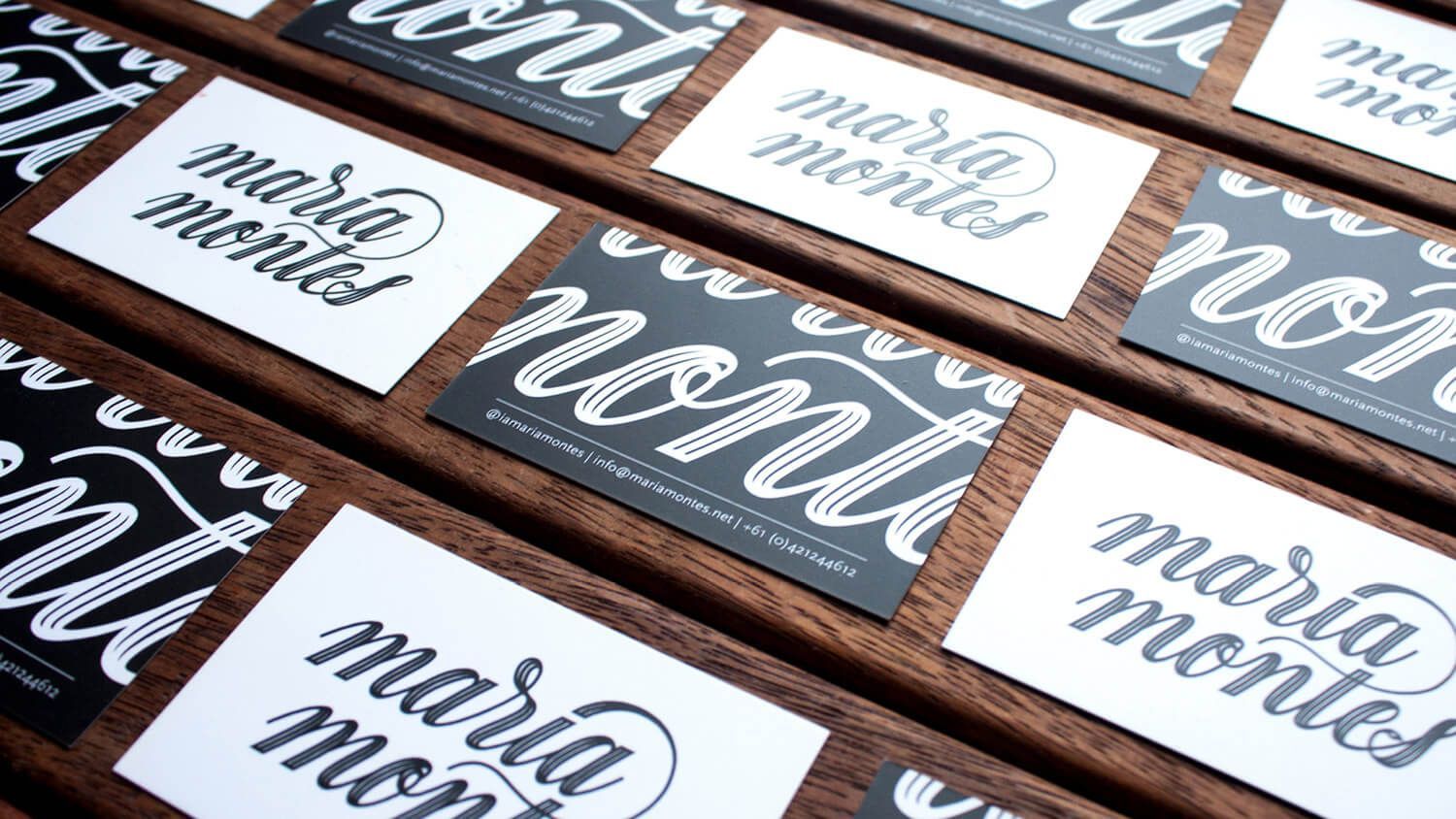 Stacked black and white “maria made” cards on a wooden surface