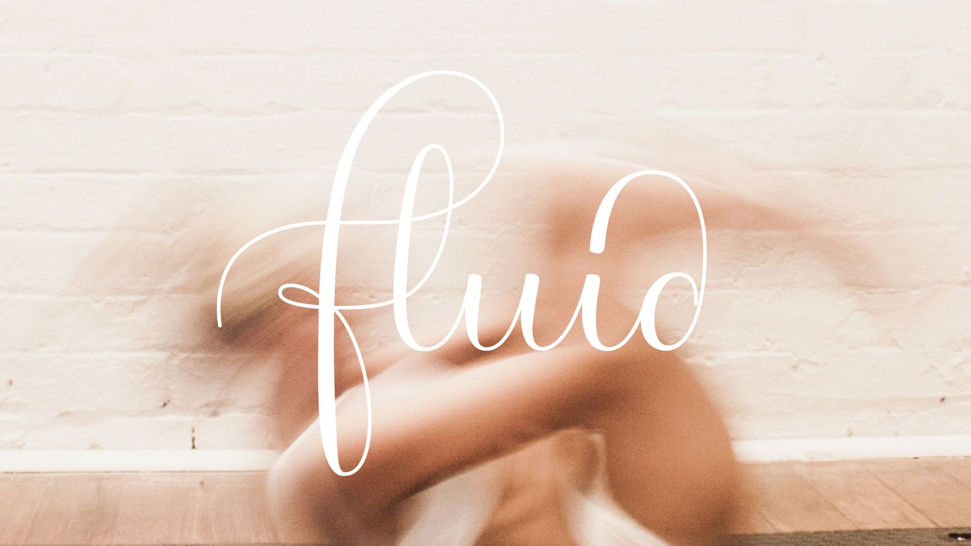 Bare feet resting on a white brick floor with the word “fluid” in white script overlaying the center