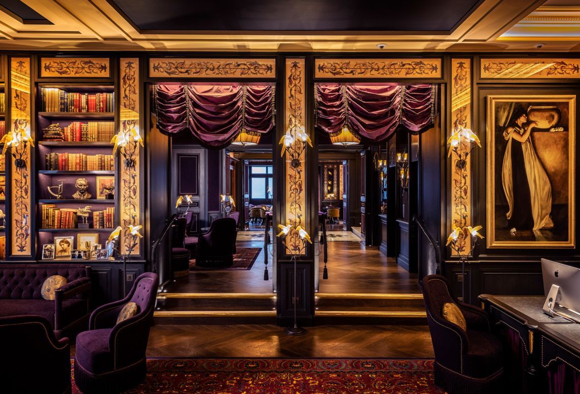 Elegant purple-and-gold boutique interior with chandeliers, mirrored doors, and clothing displays
