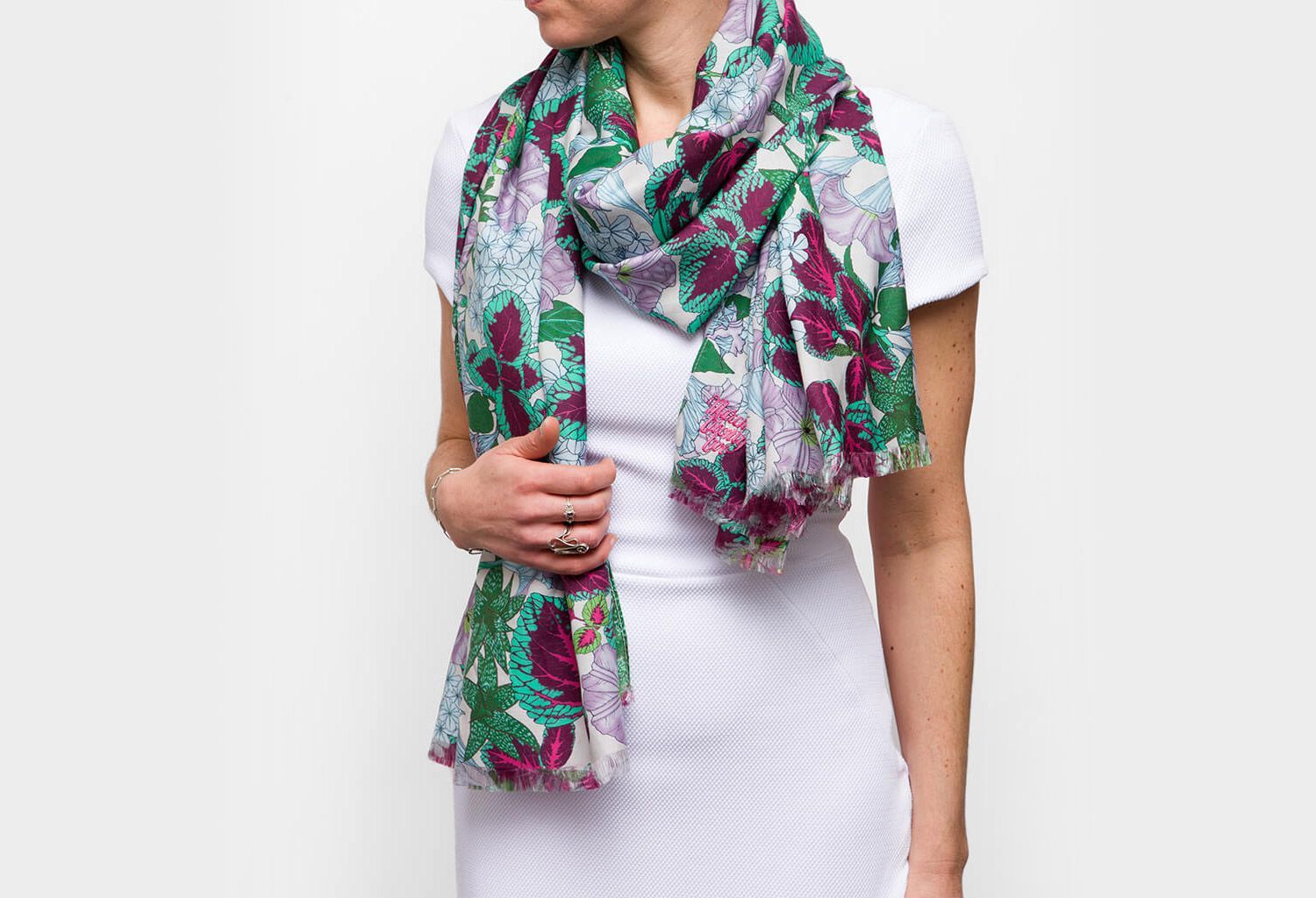 Maria Montes wearing a white dress and colorful floral scarf against a plain white background
