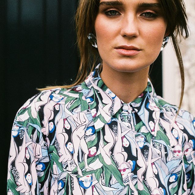 Person in a patterned button-up shirt, facing forward with a neutral expression.