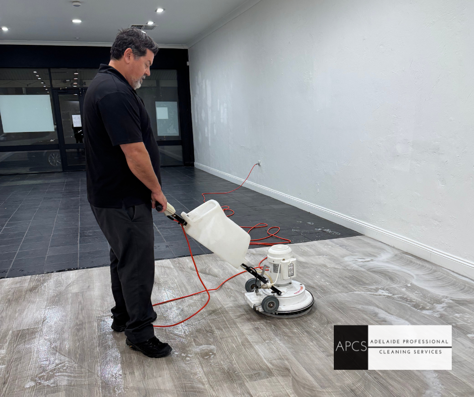 A man is cleaning a vinyl floor with a machine.