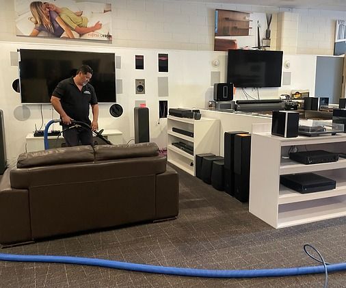 A man is cleaning a living room with a vacuum cleaner.