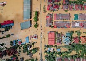 An aerial view of a flooded city with lots of buildings and trees.