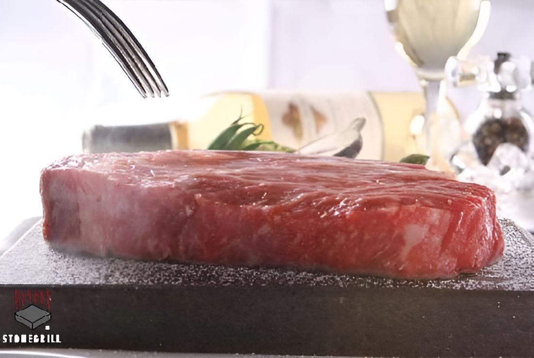 A Steak Is Being Cut With A Fork On A Plate — Stonegrill Huskisson In Huskisson, NSW