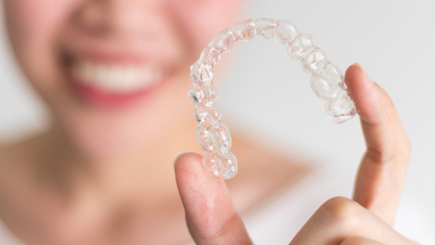 Woman Holding Invisalign — Kingston, NY — Joseph Diacovo, DMD
