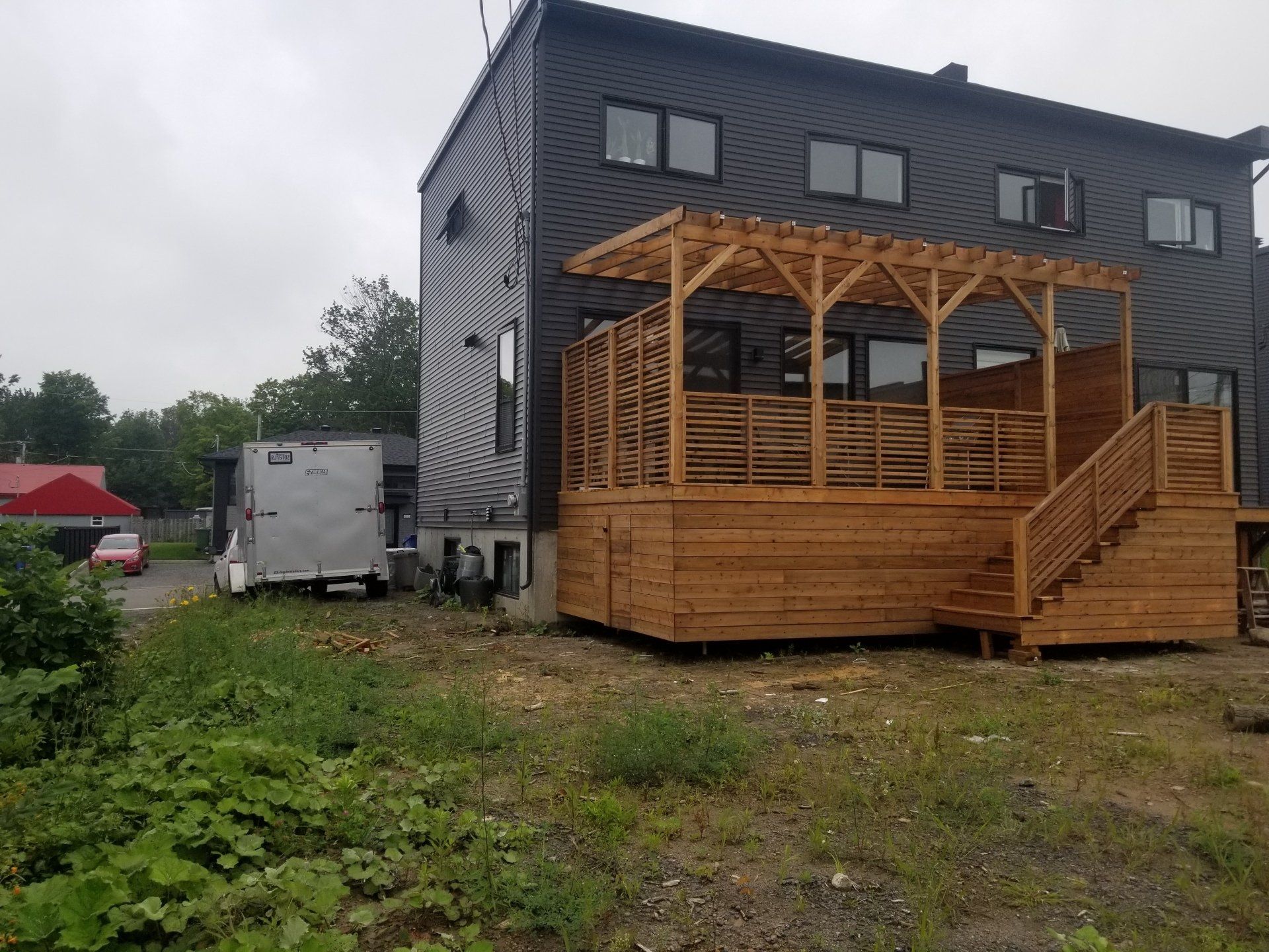 Une maison avec une terrasse en bois et des escaliers devant elle