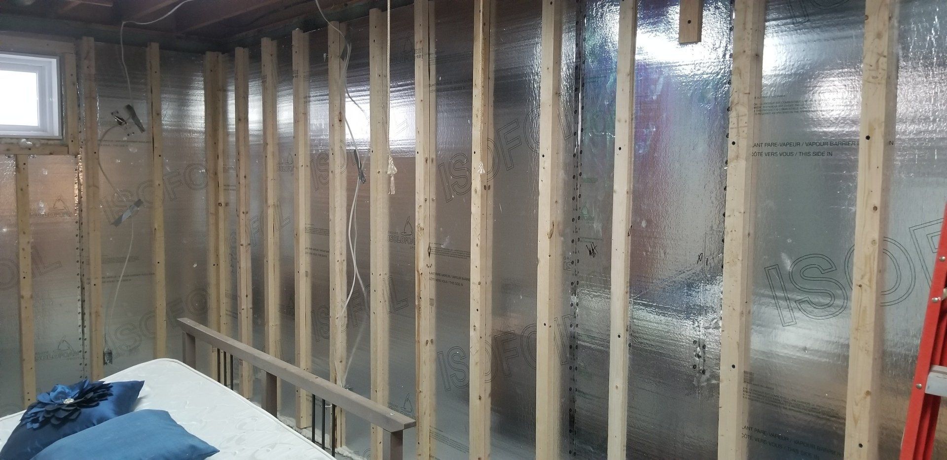 Une pièce avec un lit et une échelle dedans.