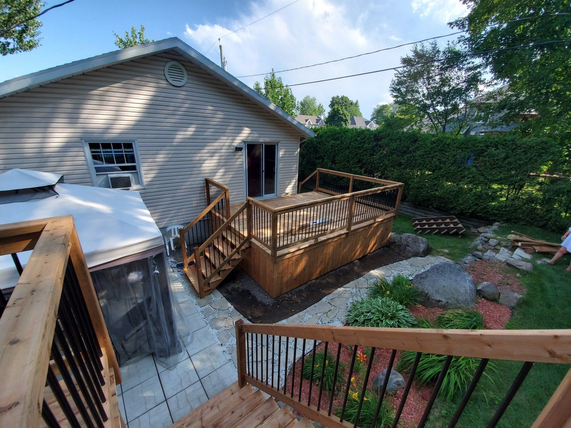 Une maison avec une terrasse en bois et des escaliers dans l'arrière-cour.