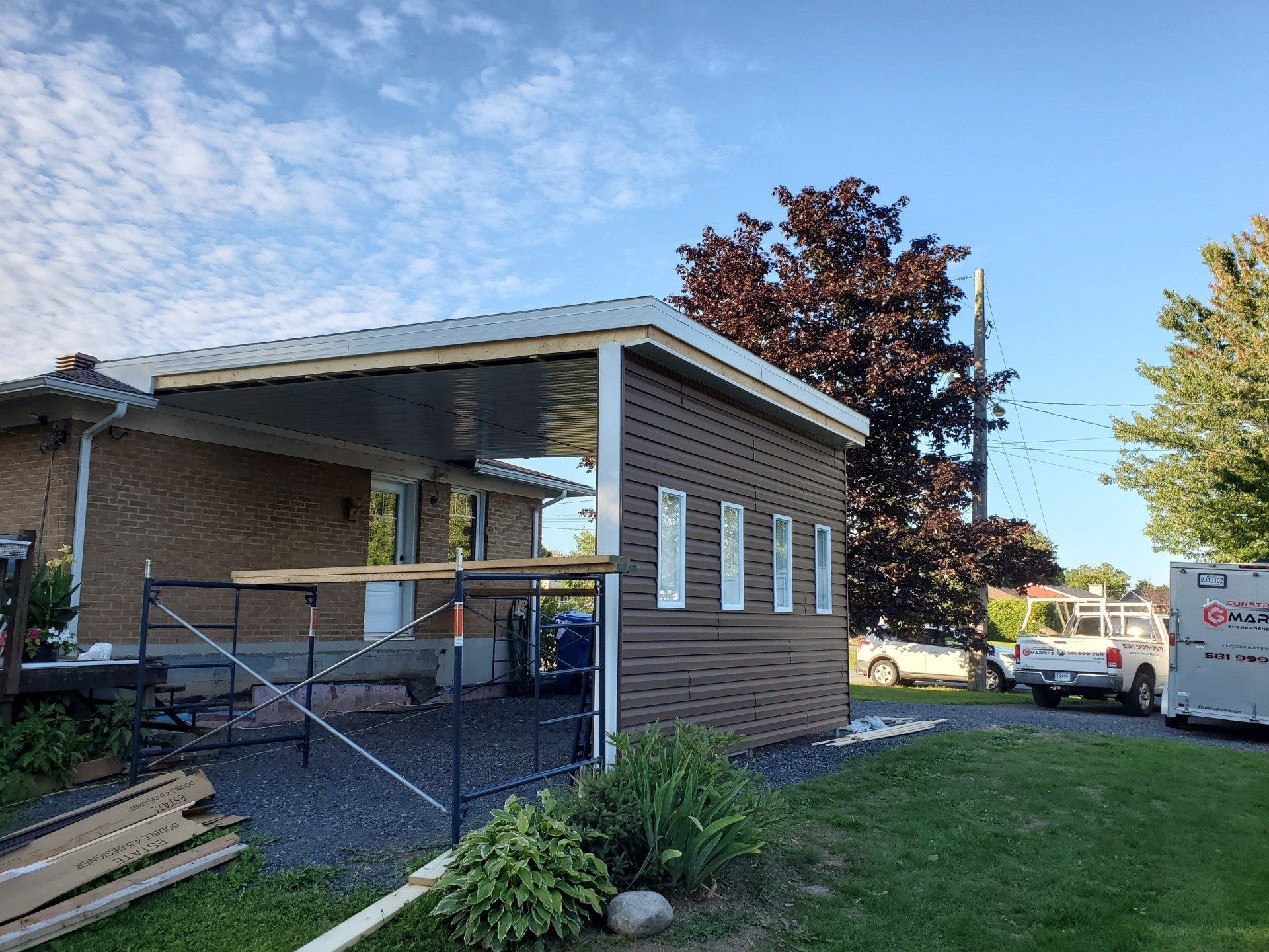 Une maison avec un porche en construction sur le côté.