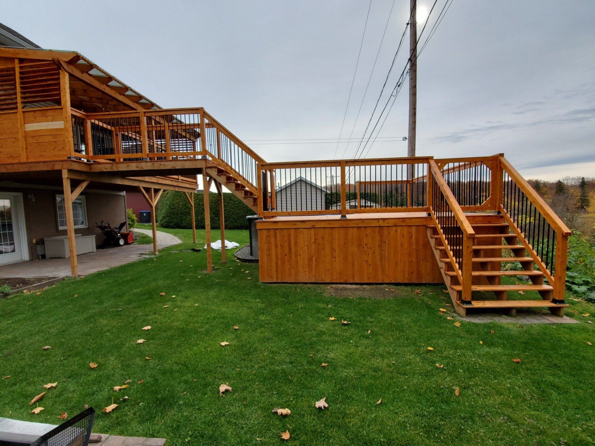 Une terrasse en bois avec des escaliers qui y mènent se trouve dans l'arrière-cour d'une maison.