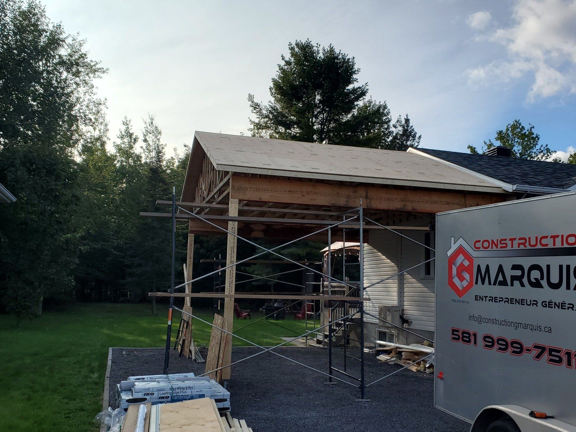 Le camion de construction d'Ag Marquis est garé devant une maison en construction