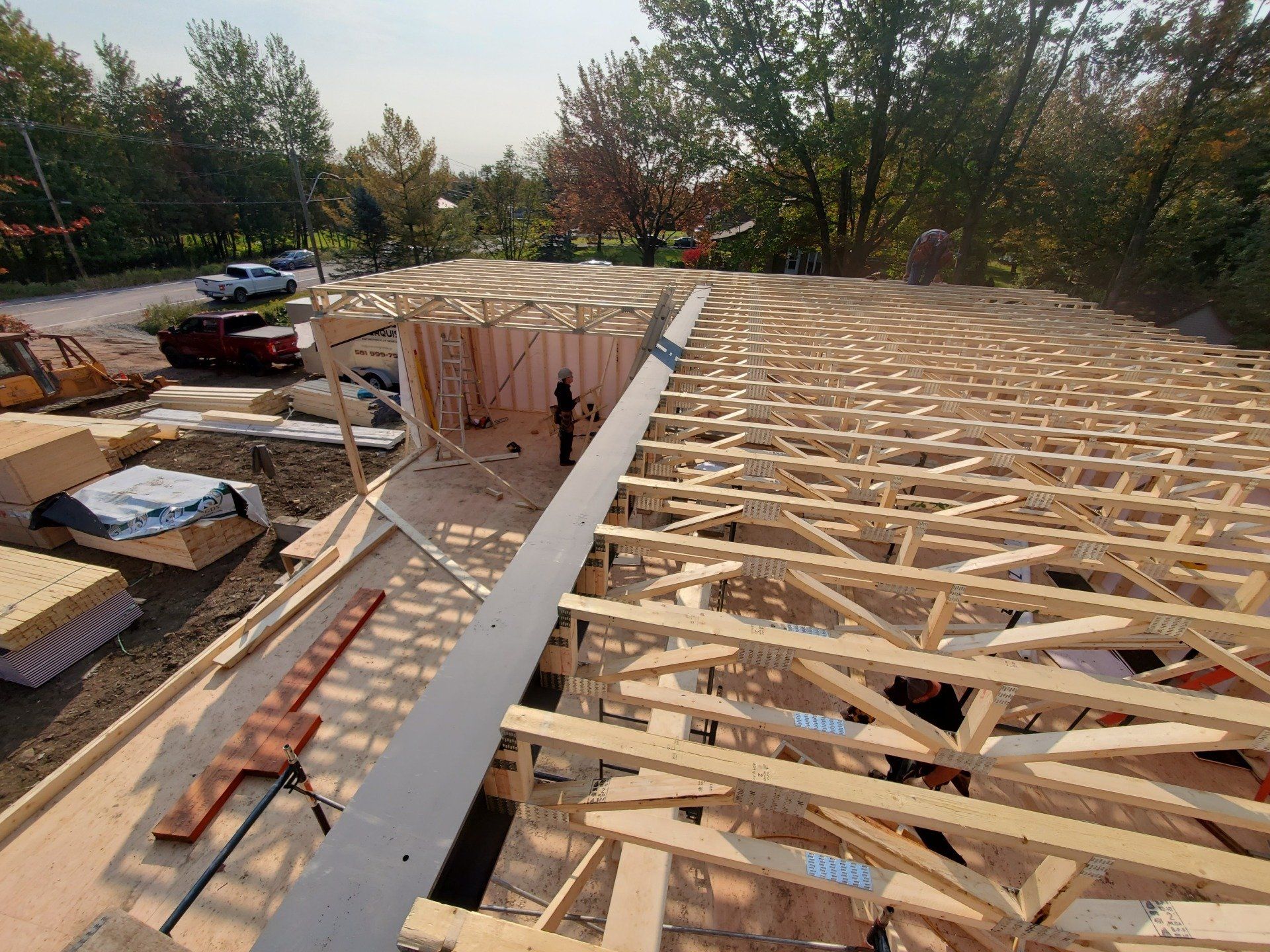 Le toit d'une maison est en train d'être construit avec des poutres en bois.