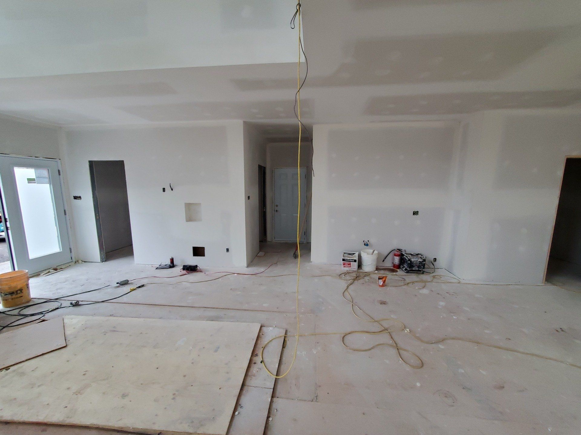 Une grande pièce avec beaucoup de murs blancs est en cours de rénovation.