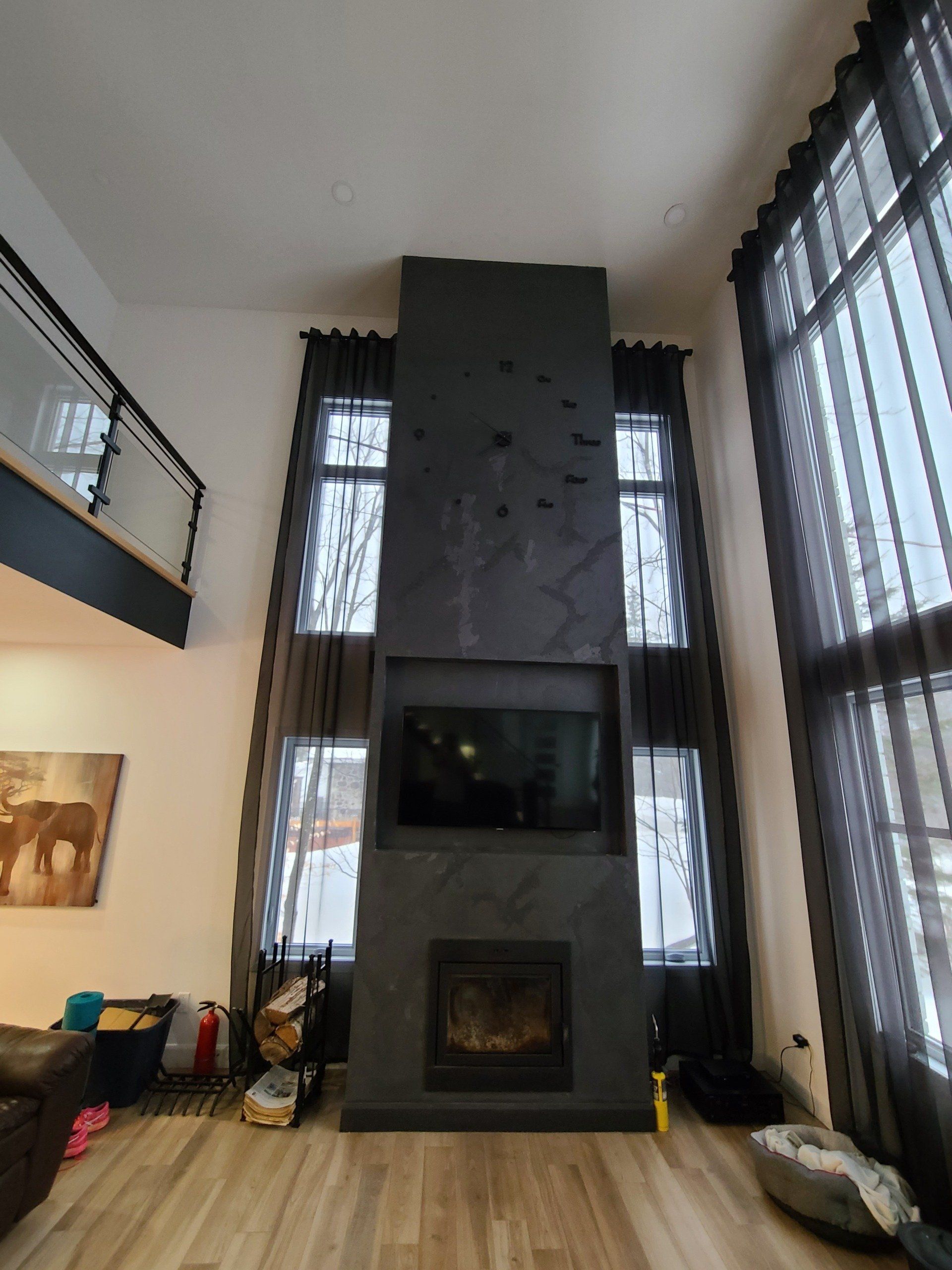 Un salon avec une cheminée et beaucoup de fenêtres