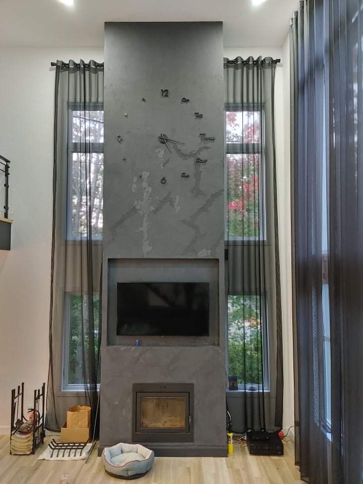 Un salon avec une cheminée et une télévision au mur.