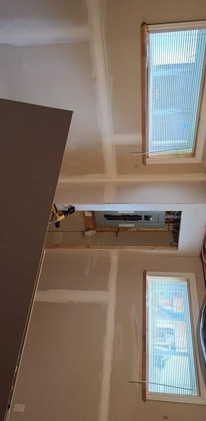 Une pièce avec deux fenêtres et un plafond en cours de rénovation.