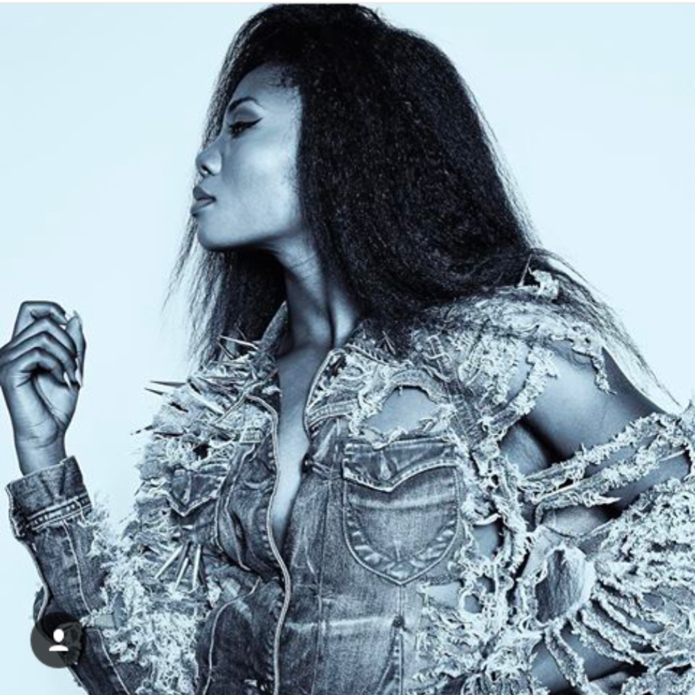 A black and white photo of a woman wearing a ripped denim jacket