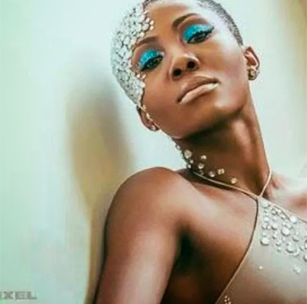 A woman with blue eye shadow and rhinestones on her face