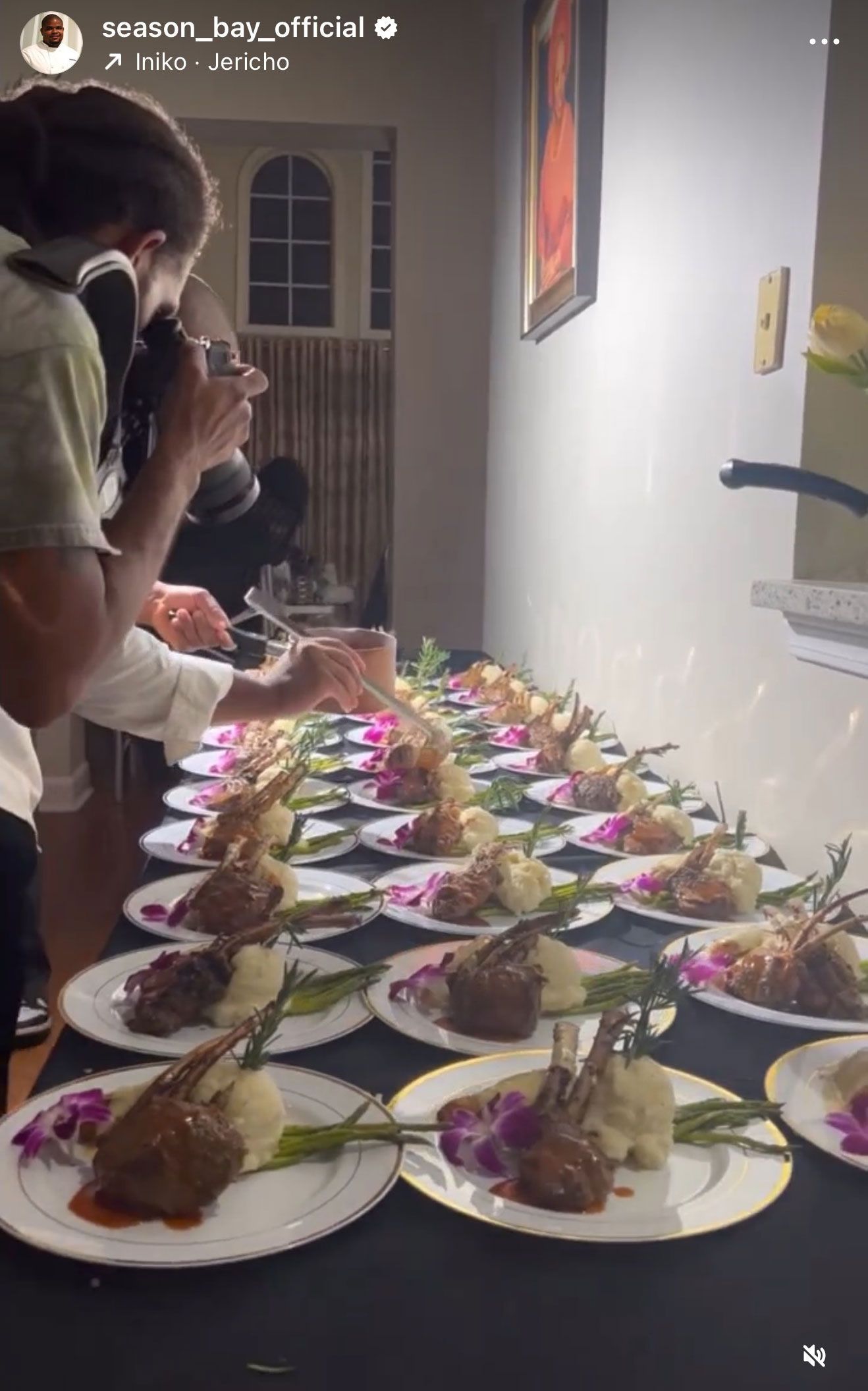 Plated food lined on a table, being photographed. A photographer captures the meal.