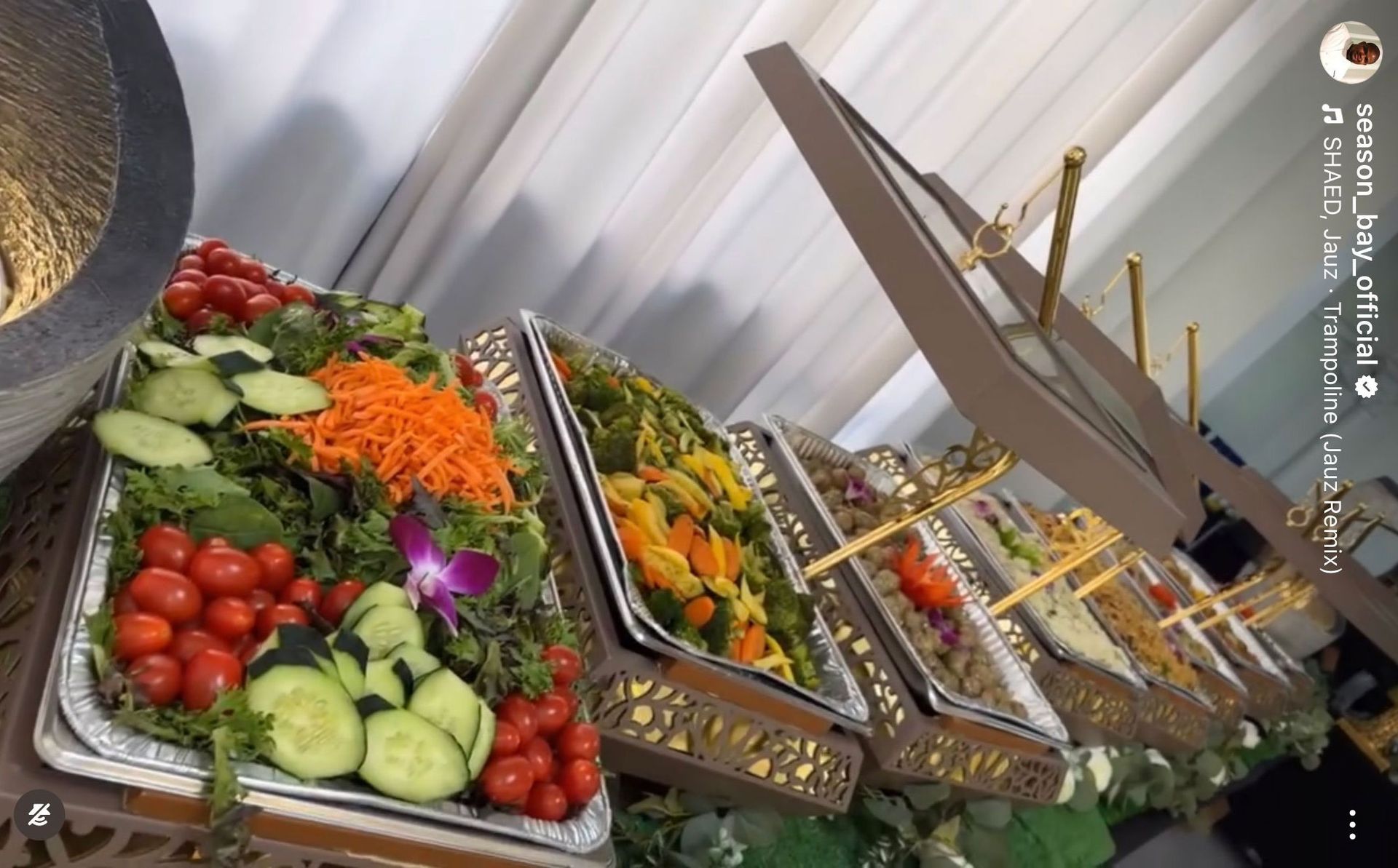 Buffet with various colorful salads in silver trays.