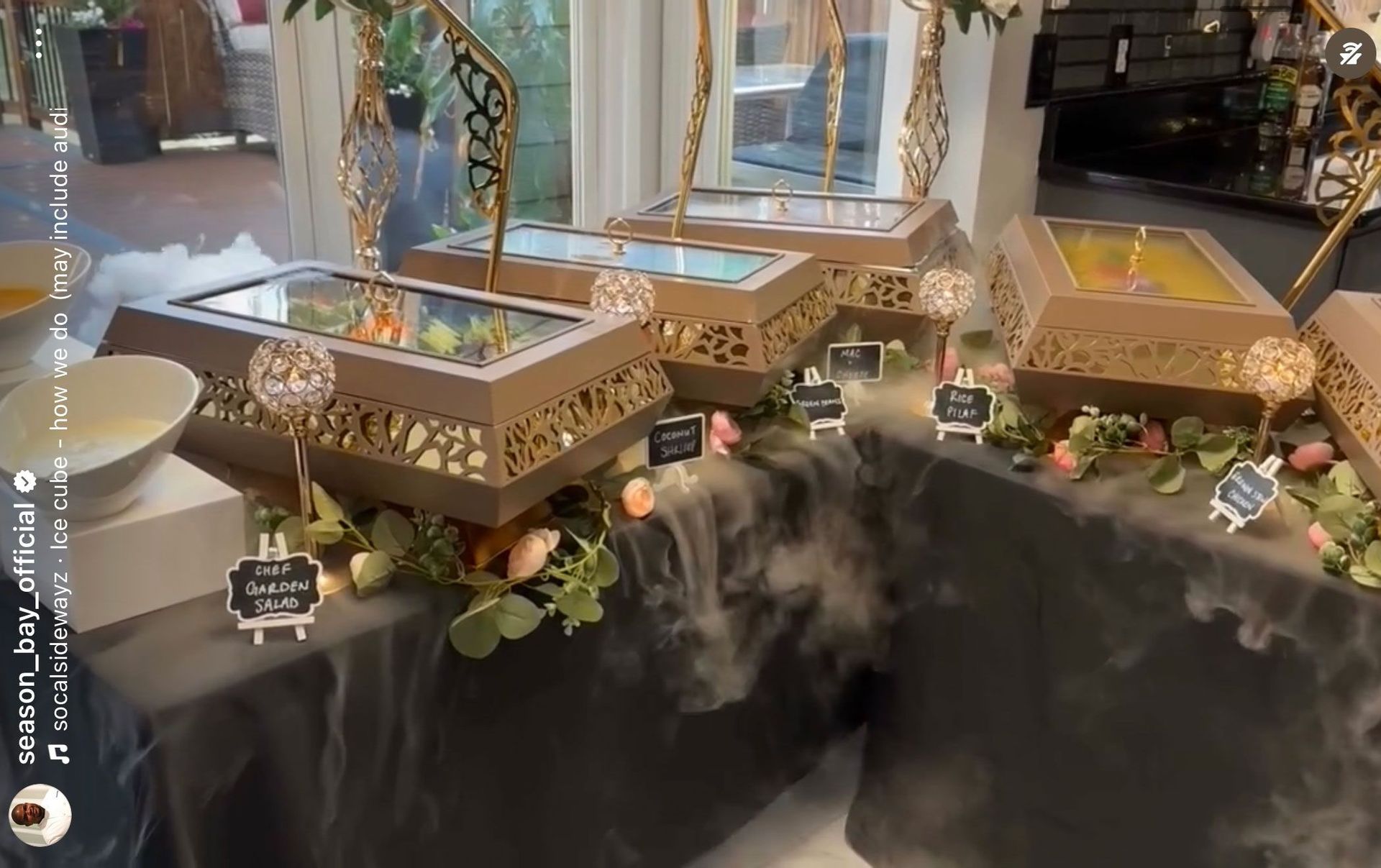 Buffet with food in decorated containers, dry ice, and signage.