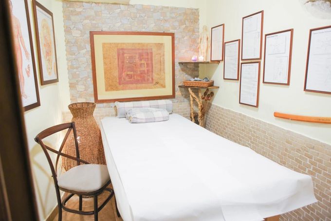 Due professionisti sanitari in camice bianco sorridono dietro una scrivania in un ufficio, con una cartella clinica e uno stetoscopio.