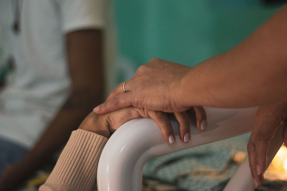 Hand on a white chair armrest in a warmly lit room