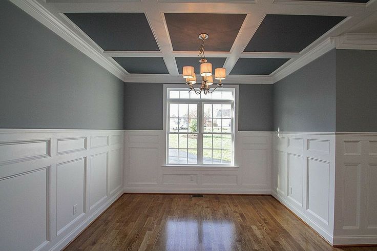 A man is working on a wall in a room.