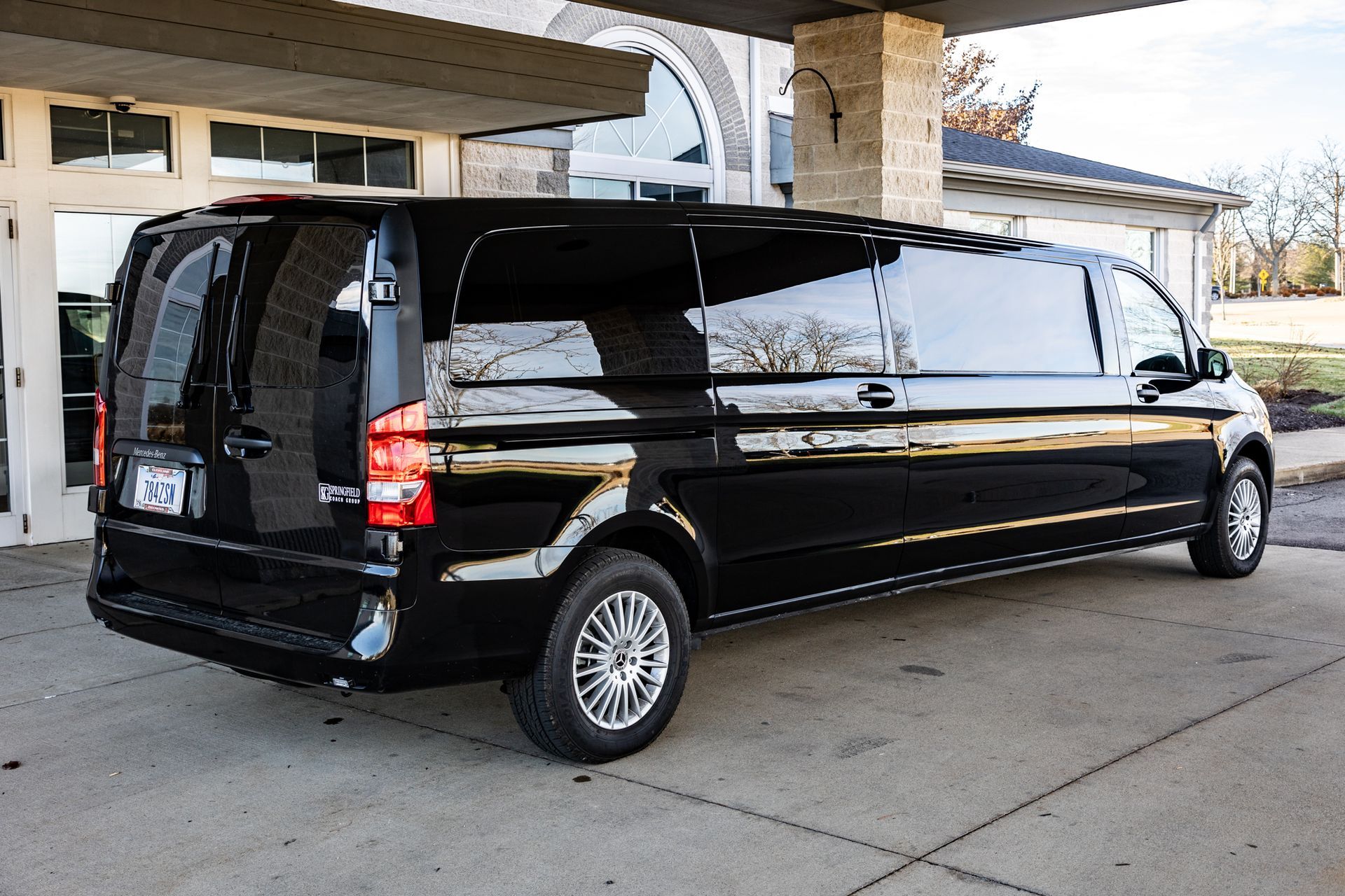 A black limousine is parked in front of a building.