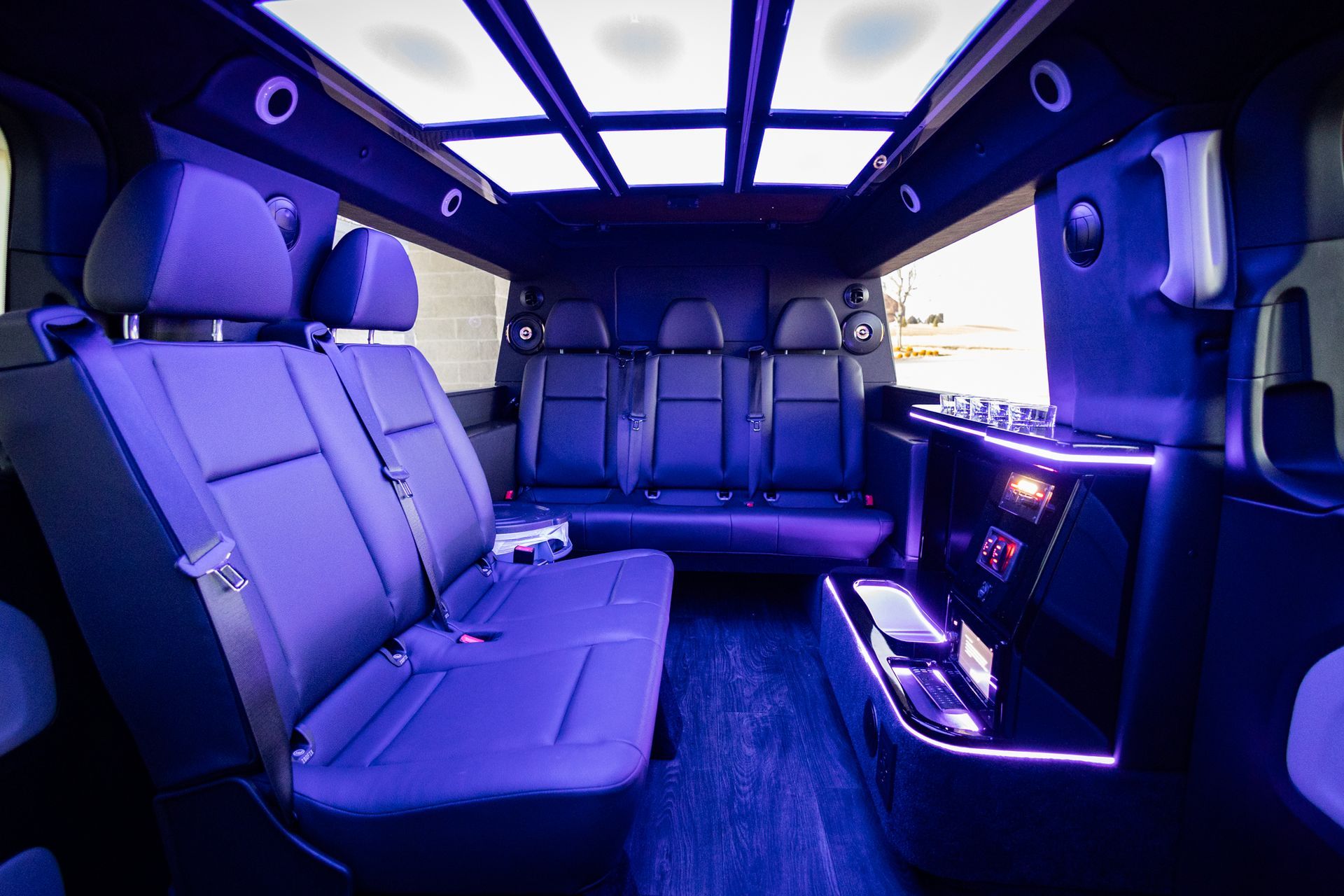 The inside of a van with purple seats and a blue ceiling.