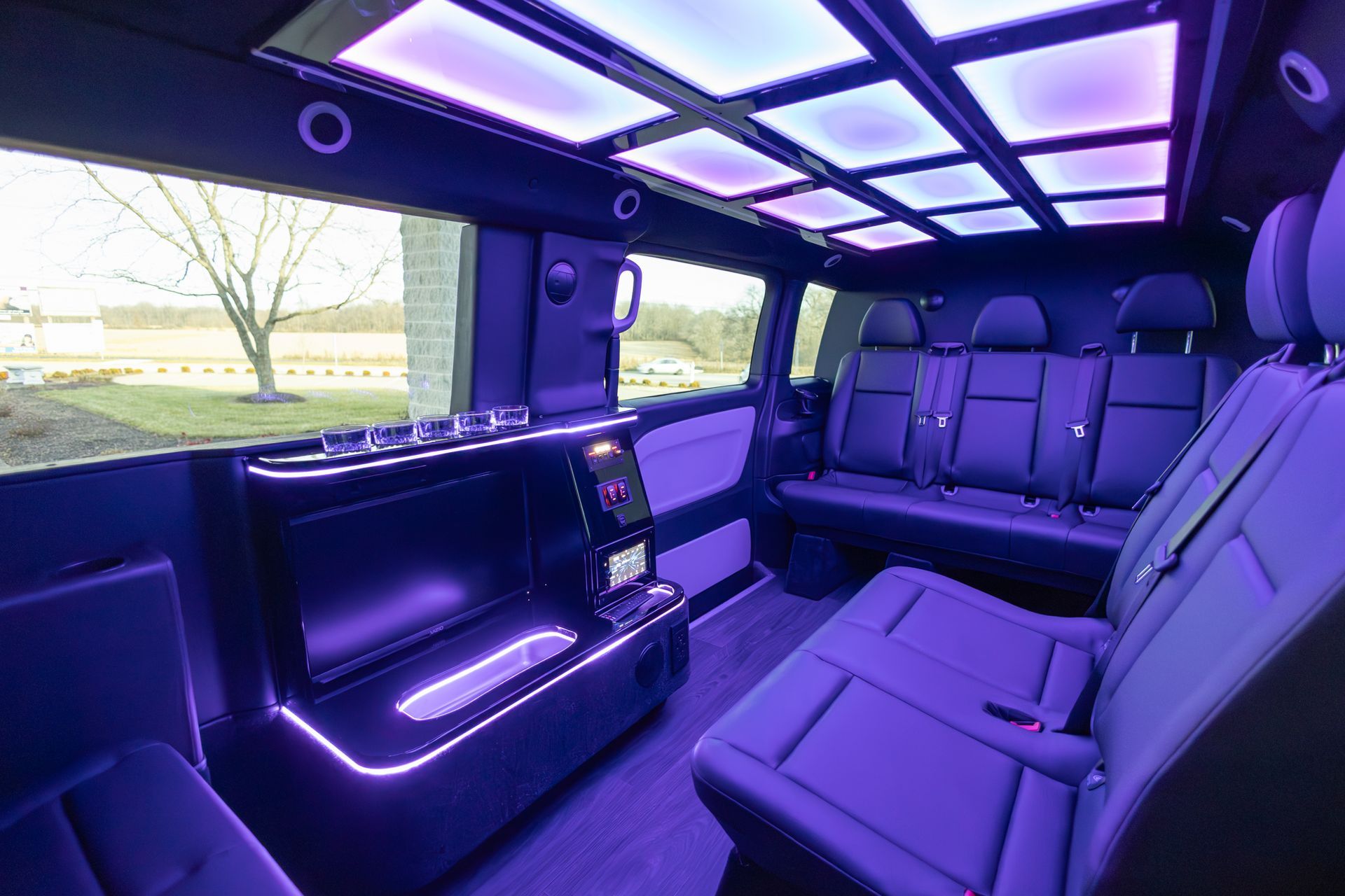 The inside of a van with purple lights on the ceiling.