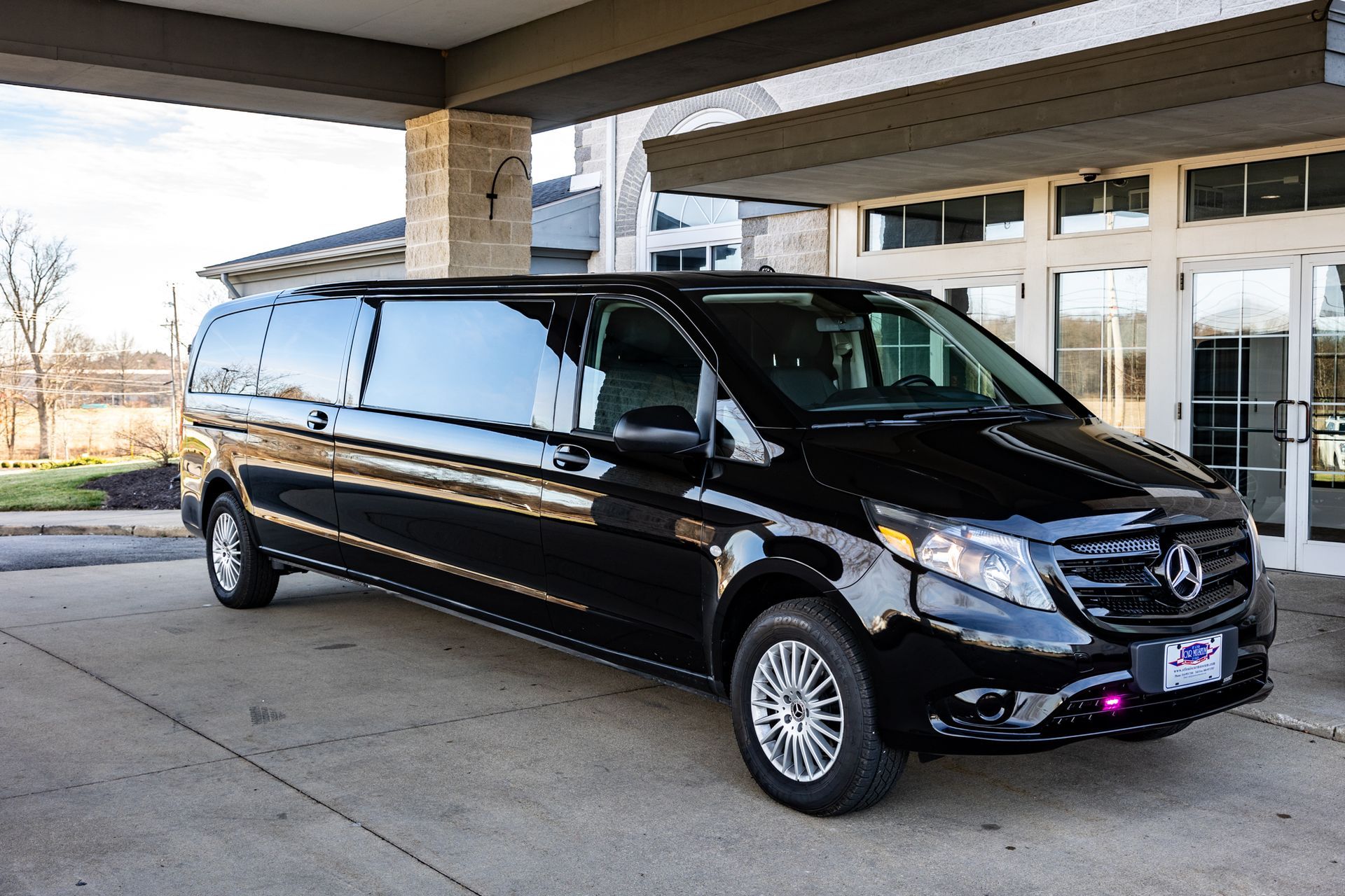 A black van is parked in front of a building.