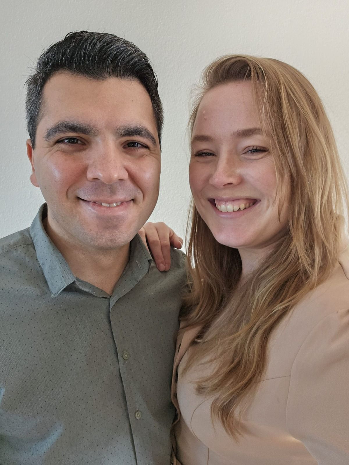 Een man en een vrouw poseren samen voor een foto en lachen.