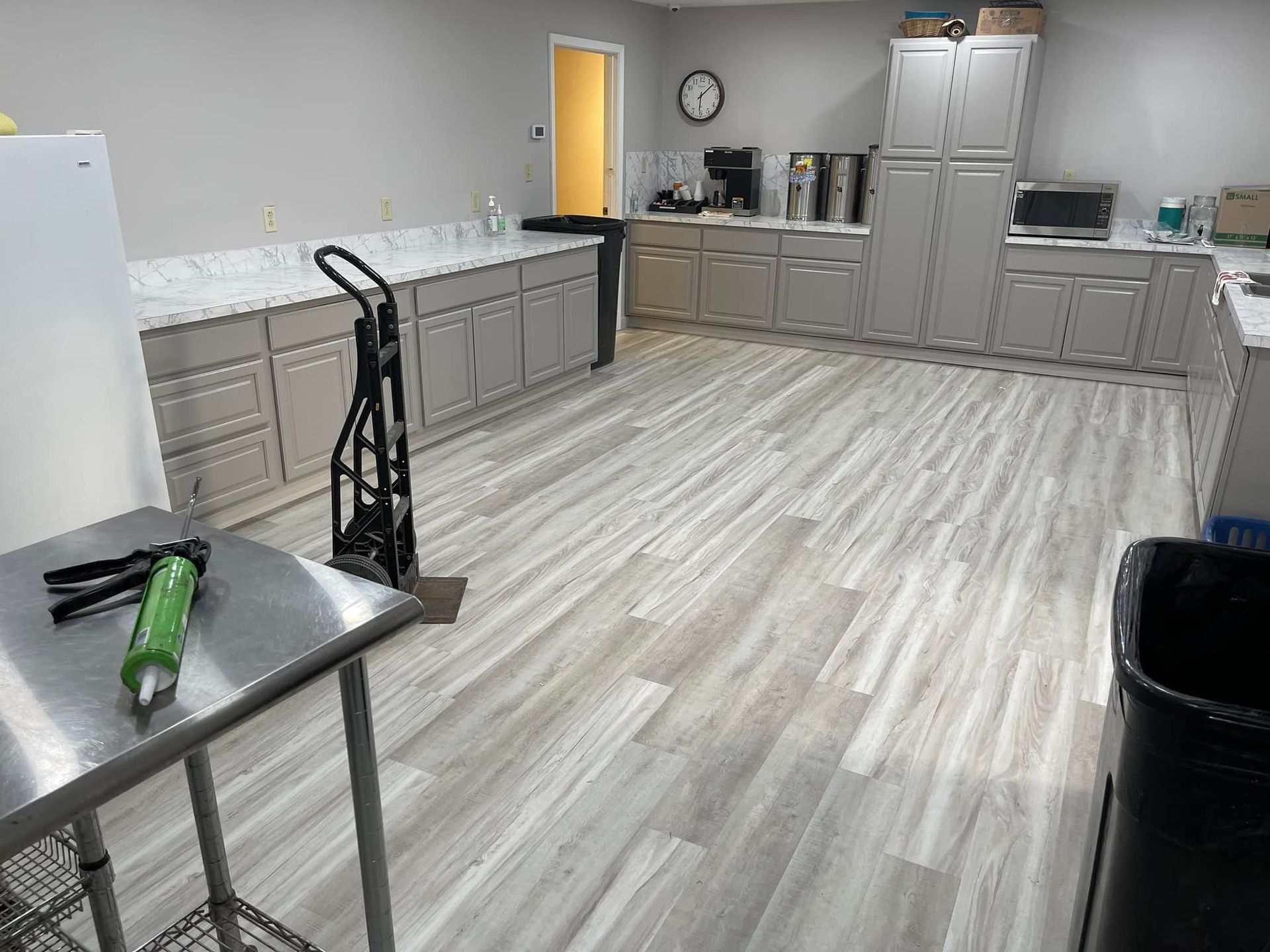 A large kitchen with a stainless steel table and a cart.