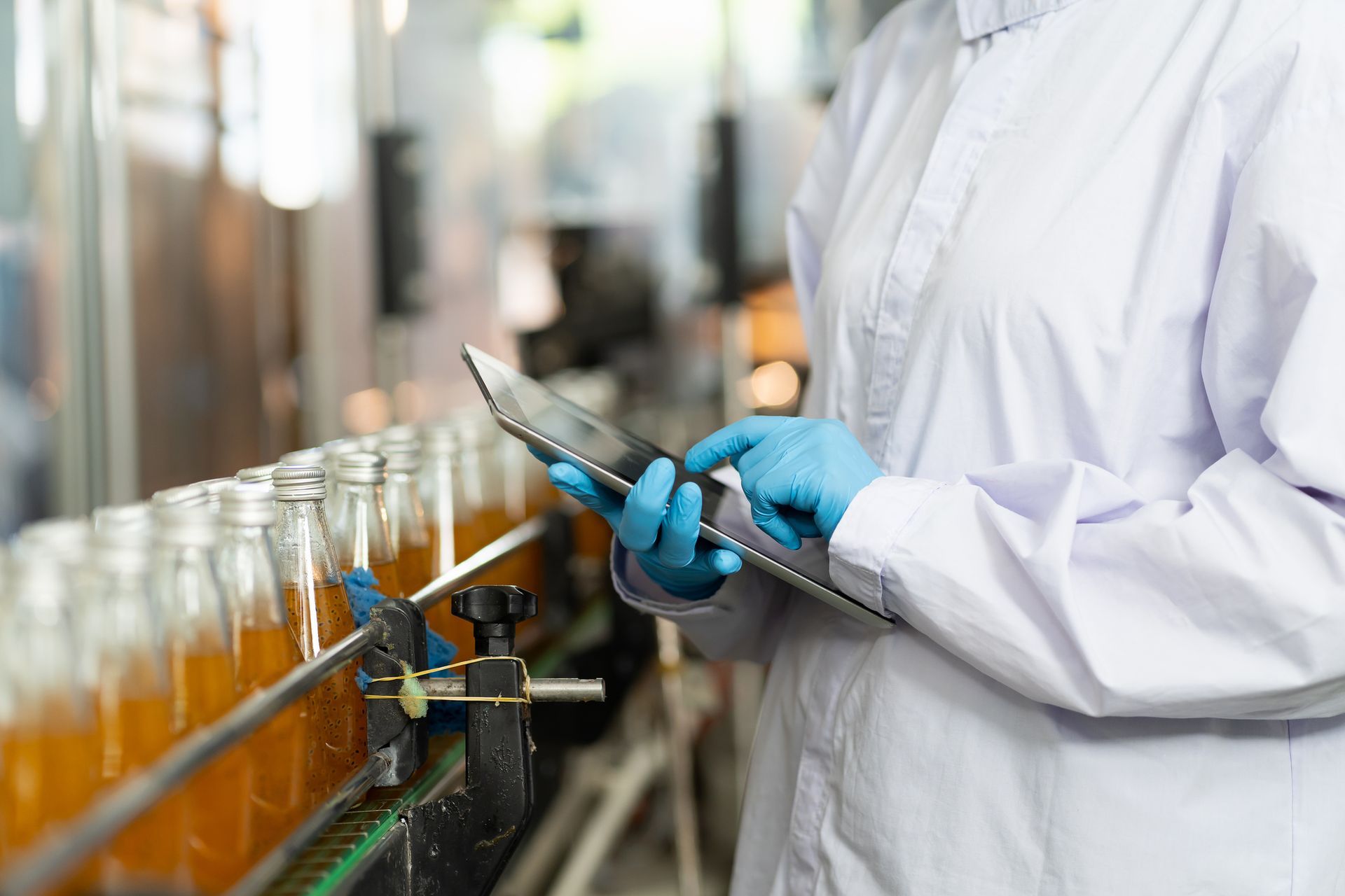 A scientist is using a tablet computer in a factory.