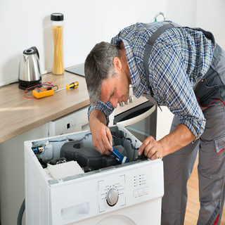 Repair Shop For Appliances — A Man Fixing The Range in Westerly, RI