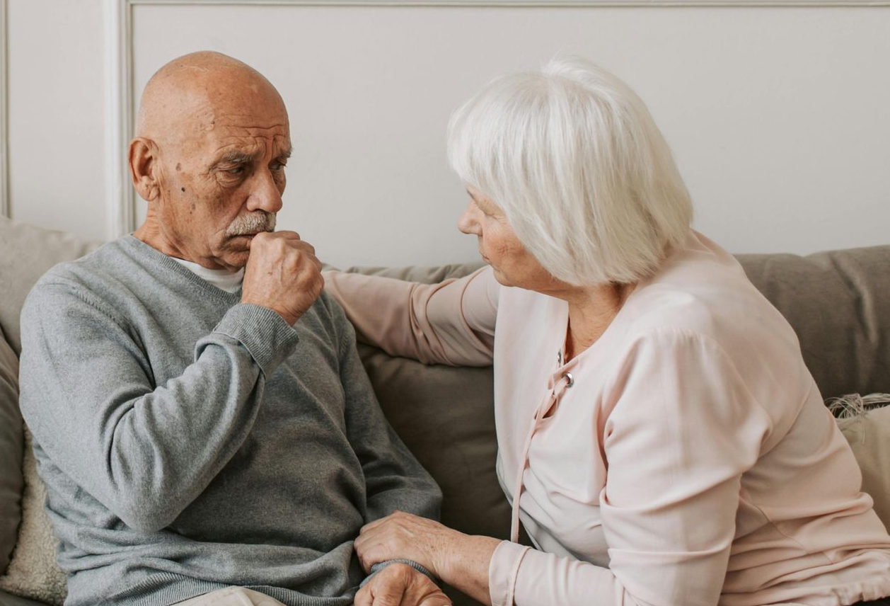 sick man being comforted by his wife