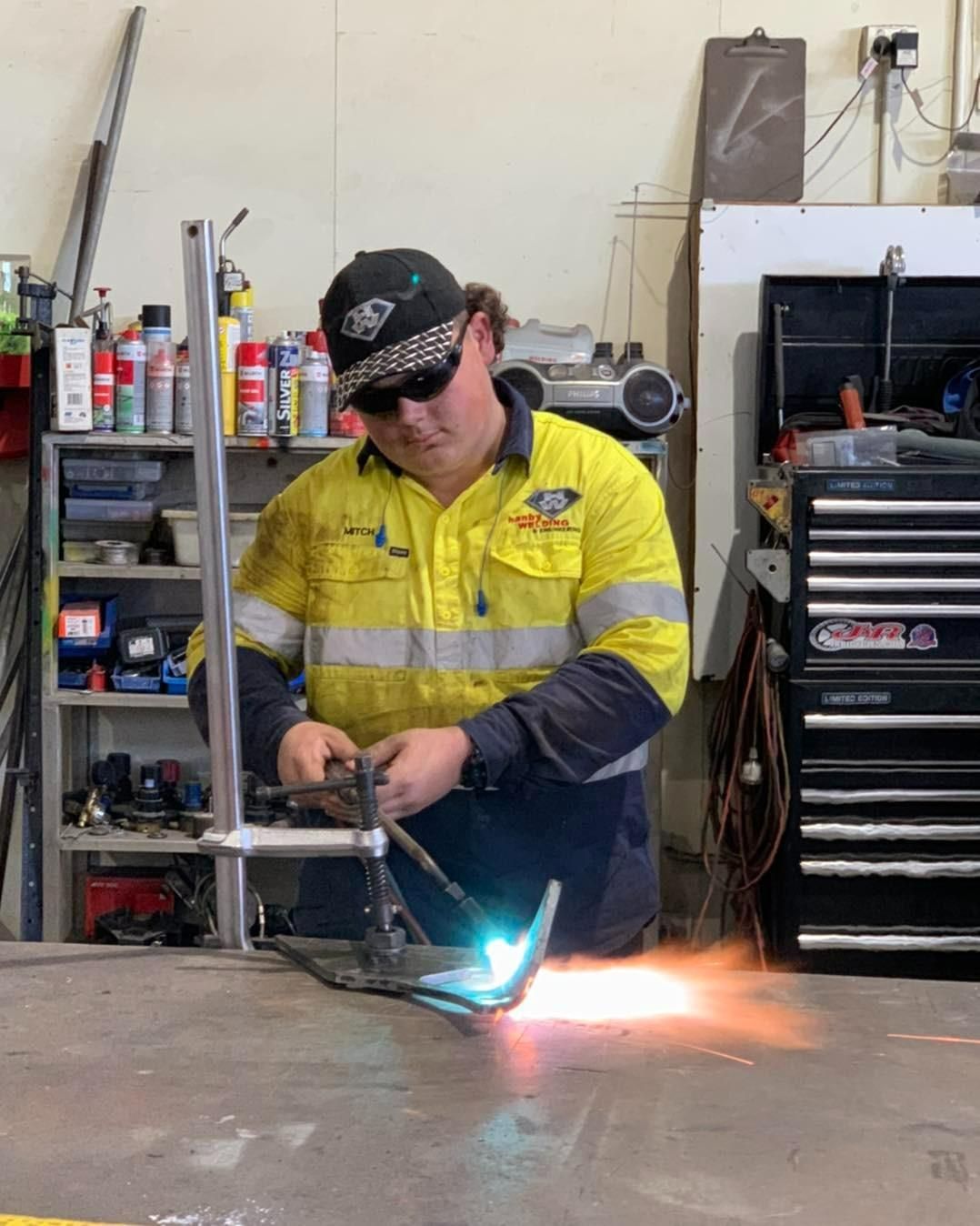 A Man Is Welding A Piece Of Metal In A Garage — Hanby Welding & Engineering In Portsmith, QLD
